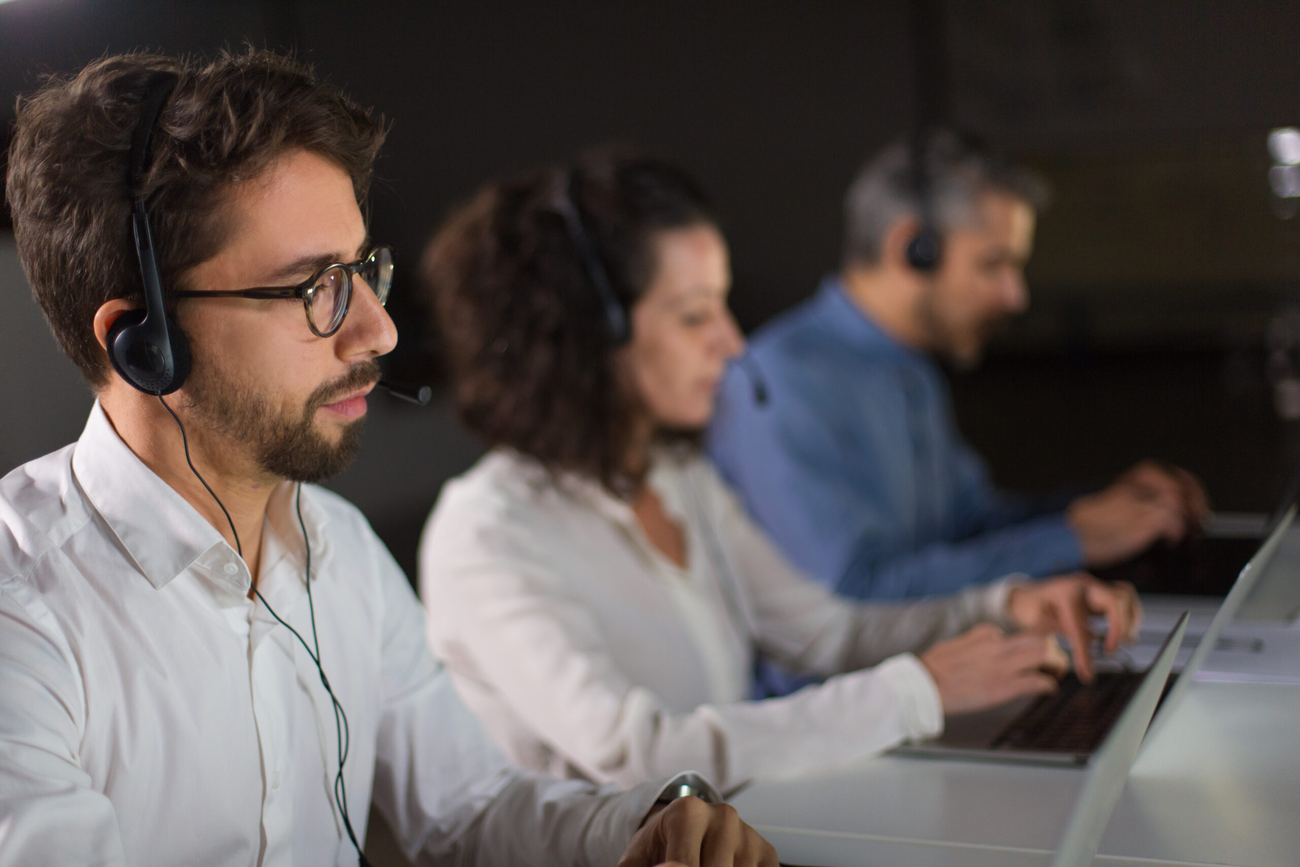 Concentrated bearded call center operator working. Thoughtful call center operators during working process. Call center concept